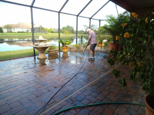 He's still working. We move all the plants to one side so he can wash where they were. He even cleans the fountain using the machine. 