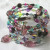 This multi-wrap coil bracelet features a combination of vintage and contemporary glass beads and pressed glass bead dangles in an interesting mix of cool shades. This multi-wrap coil bracelet features a combination of vintage and contemporary glass beads and pressed glass bead dangles in an interesting mix of cool shades.