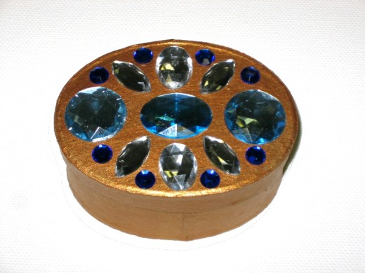Oval bronze trinket box with blue and white gems
