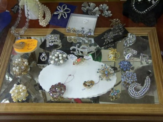 Vintage pins and brooches and other costume jewelry on display