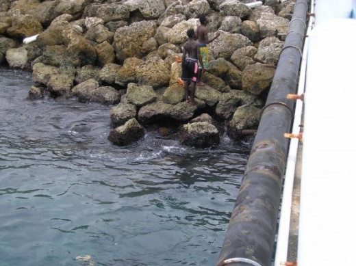 Young men diving in the water for shells
