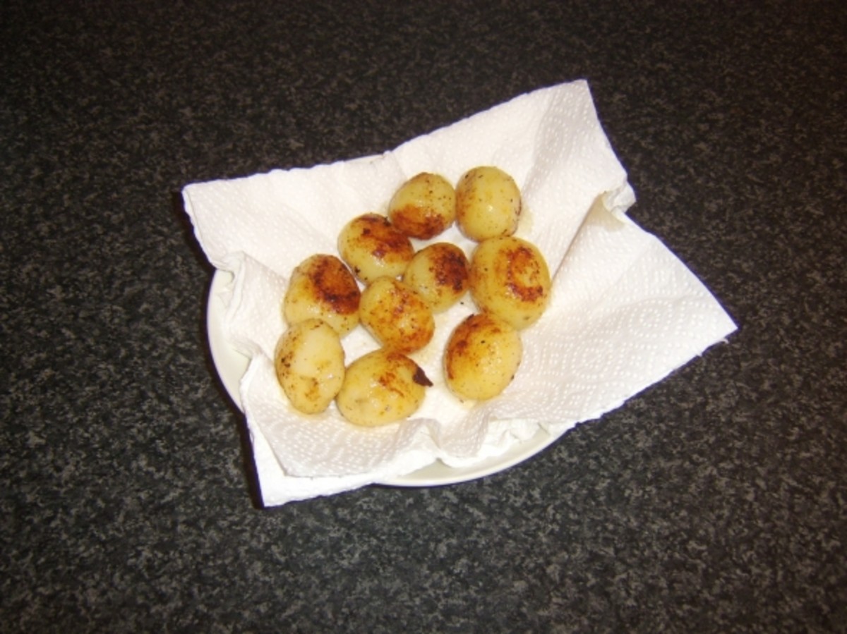 Chicken fat roasted potatoes are drained on kitchen paper before being plated
