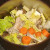 Chopped vegetables and seasonings are added to stock pot with turkey bones