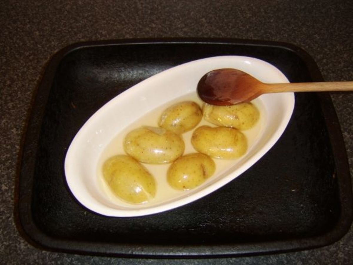 Fingerling potatoes are carefully stirred in hot goose fat