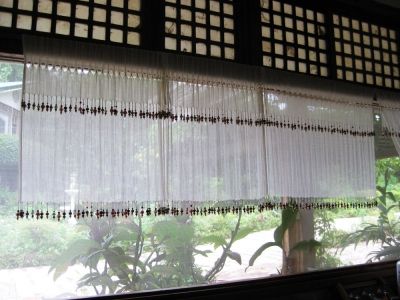 Sheer curtains were weighed down by dangling handmade beads