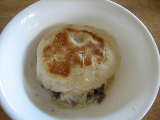 place one half of the grilled, toasted English muffin on top and carefully flip the ingredients in the dish on to the muffin top. 