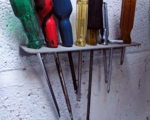 An assortment of old screwdrivers hanging up in the workshop