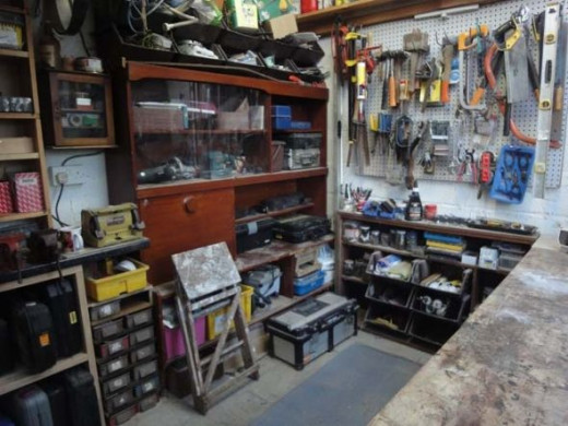 Glass unit and other old furniture utilised for storing DIY woodworking tools