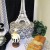Right- Black and white Eiffel Tower on top of a damask hat box, a jolly French Chef, some greenery  and a white marble cake on a Fosteria platter.