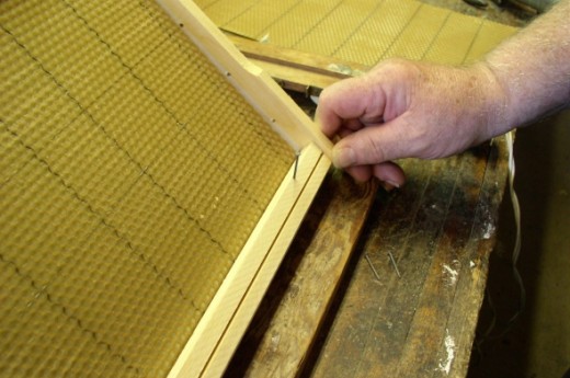 Beekeeper assembles a frame. 