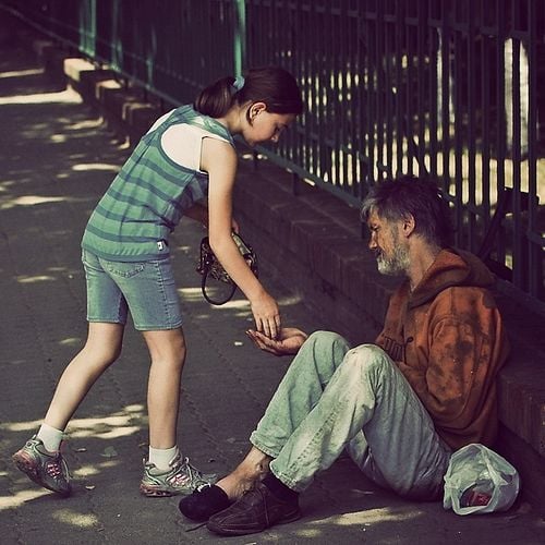 This young lady is giving money to a poor man.