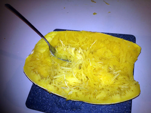 Take a fork and begin pulling the meat of the squash towards the middle. The squash will shred easily into stringy pieces.