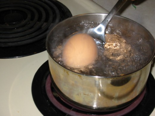 Before boiling the macaroni, take out a medium-sized pot to boil the eggs and carrots in.Place the eggs and peeled, halved carrots (not shown in picture) into the pot of cold water . Add a pinch of salt to the water, then start boiling them for abou