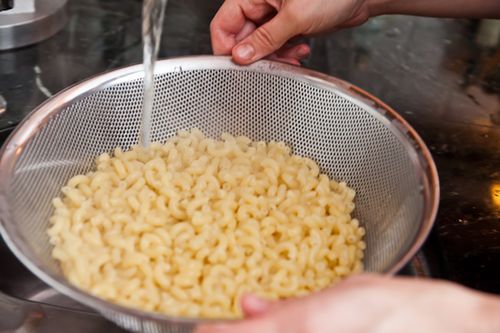 If the macaroni is done, turn off the burner.Put on oven mitts to take the pot to the colander in the sink for draining.Rinse well. Pour the rinsed, drained macaroni into a large salad bowl, then set aside.