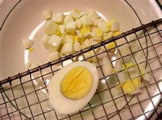 Then, peel the hard-cooked eggs and chop or use an egg slicer to slice the eggs before adding them to the salad bowl.
