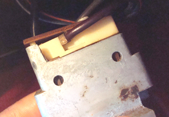 The switch. The yellowish part connects to the actual switch and can be removed. The black wire raises top when 12v is applied