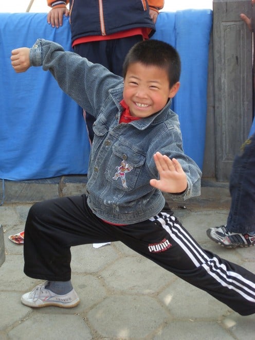 A young boy showing off his Kung Fu skills.