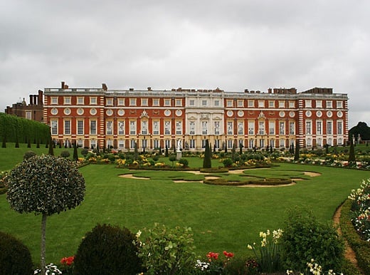 A view of the south facade of Hampton Court Palace with the formal garden in front of it.
