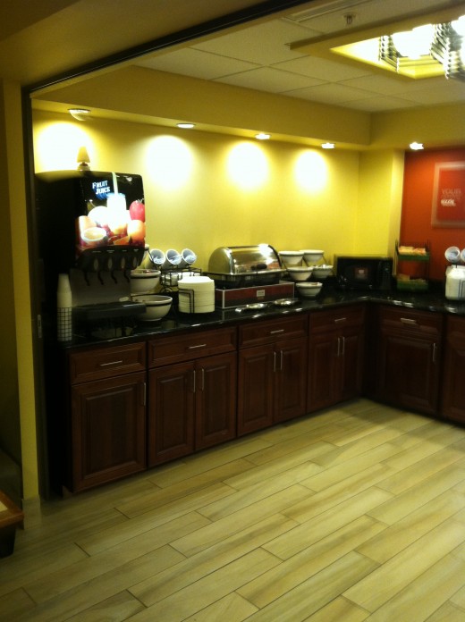 Breakfast area with bowls of fruit and chafing dishes filled with hot foods.