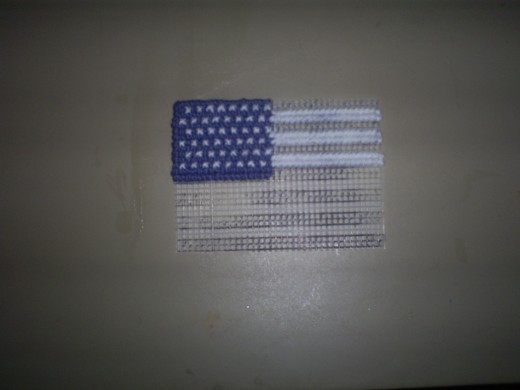 Begin cross stitching on the white stripes of the American flag.