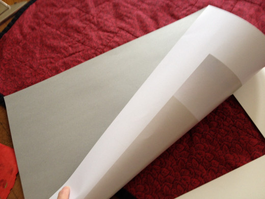 Step 4. Place the backing, photo side down, on the matting and press against the tape to secure. This is the surface on which you will mount the decorative paper.