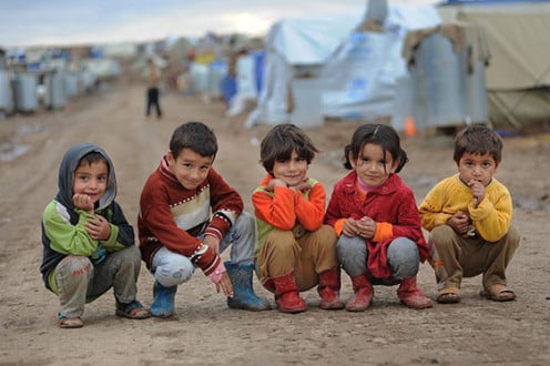 Syrian refugees posing outside of a camp