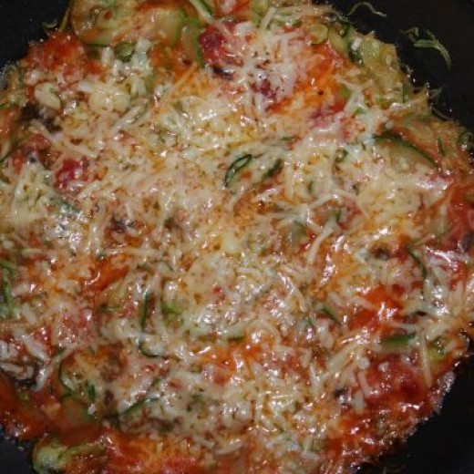 Spiral zucchini with tomato sauce and shredded cheese.