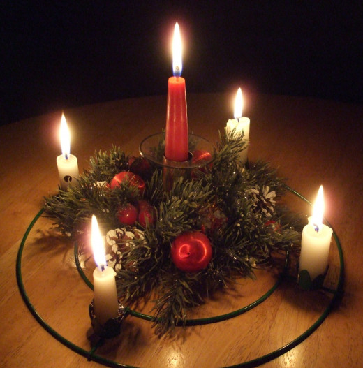 A Christmas Advent wreath with lit candles for Christmas Eve.