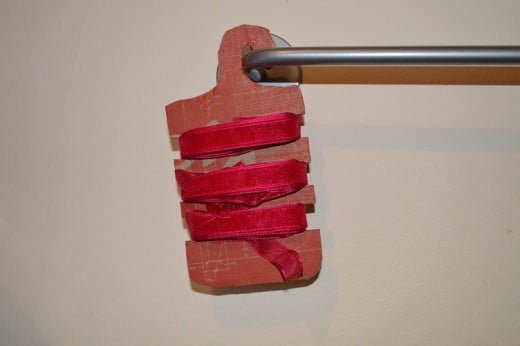 A shoe box that has been up-cycled into a hanging ribbon holder