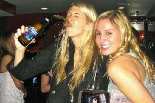 Notice how this pretty girl simply smiles as her friend guzzles down beer, and not realizing that he is spilling beer causing a scene