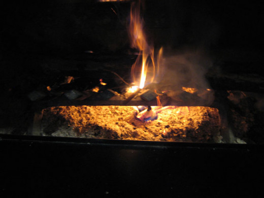 Place the cup under the wood as shown and light it. The steady flame from the firestarter will start the kindling on the bottom of the prepared fire as shown.