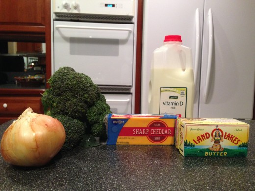 Sweet onion, broccoli bunch, cheddar cheese block, whole milk, and butter.