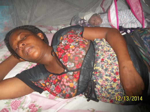 A woman sleeping during the night with her baby behind