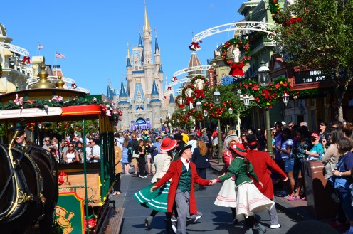 Christmas holiday dancers entertain guests on Main Street U.S.A in The Magic Kingdom at Walt Disney World. Cinderella's Castle is in the background.
