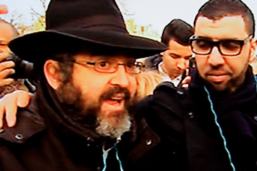 A Jew is interviewed on camera on Sunday 11th January 2015. The man with the arm around his shoulder is his Muslim friend