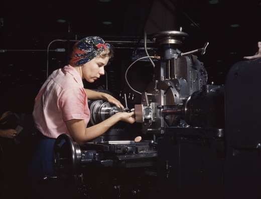 A woman uses a scarf as a turban to keep her hair out of her face and away from the machinery on the job.