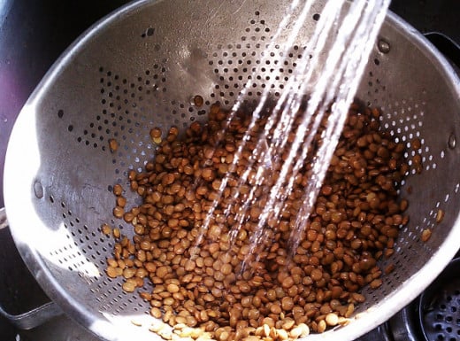 Empty a bag of dried lentils into a container. Pick them up a handful at a time, look them over for rocks, and throw them in a strainer. Rinse and they're ready!