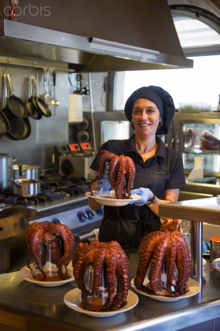 Female chef preparing a Pulpo Octopus for a lavish meal