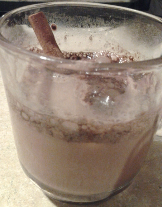 Cup of cocoa garnished with a cinnamon stick.
