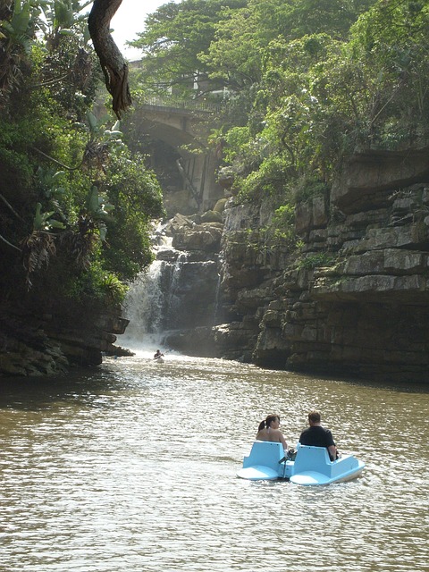 beautiful water way with cliffs on each side with a blue pedal boat with two people