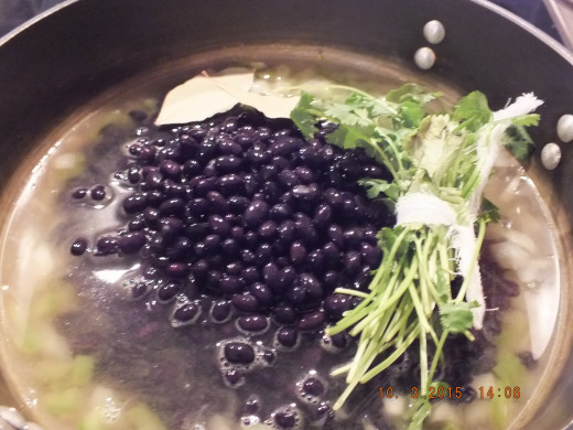 You are going to add water, black beans, a cilantro bundle, bay leaves, and salt.