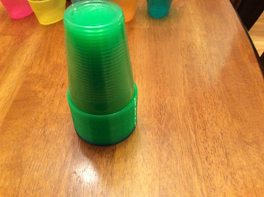 Green cups stacked on top of blue cup