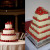 A traditional multi-layered wedding cake with each layer topped with strawberries.