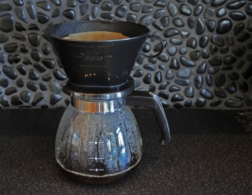 A simple cone coffee filter on a glass coffee pot.