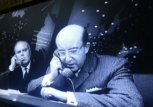 “Hello, Dmitri? I can’t hear too well. Do you suppose you can turn the music down just a little?” Peter Sellers in one of his 3 parts, as President Merkin Muffley. To the left is the skeptical Russian diplomat Alexei de Sadeski, played by Peter Bull.