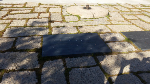 President John F. Kennedy Behind his stone is the eternal flame. It's never allowed to go out. 