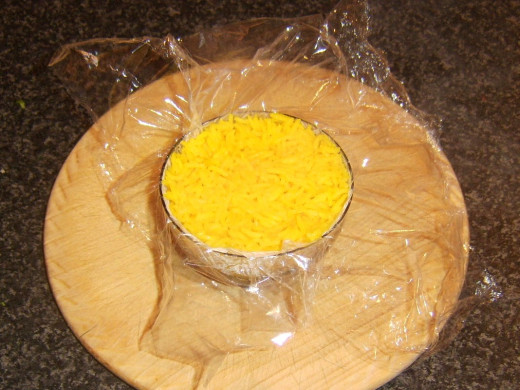 Turmeric rice is packed in to small clingfilm lined bowl