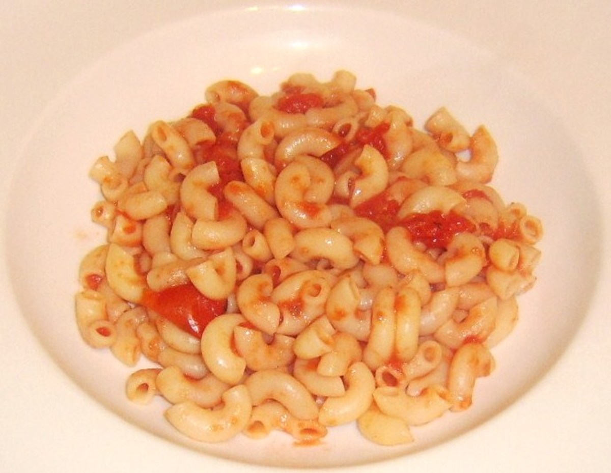 Macaroni and tomato sauce is laid in the bottom of a deep serving plate