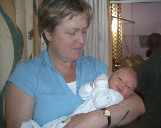 A newborn baby, 12 hours old, in a National Health Service neo-natal ward in London, and his proud grandmother