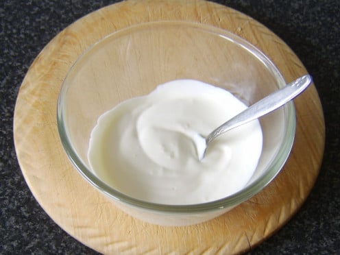 Garlic is stirred in to soured cream in a small bowl
